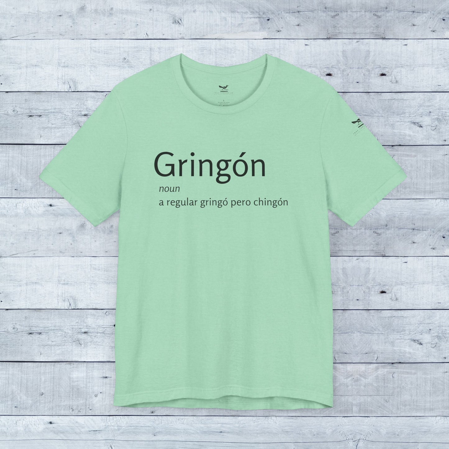 Gringón Tee close-up displays bold black text on soft green fabric, a stylish unisex crew neck for confident, cultural expression and comfort.