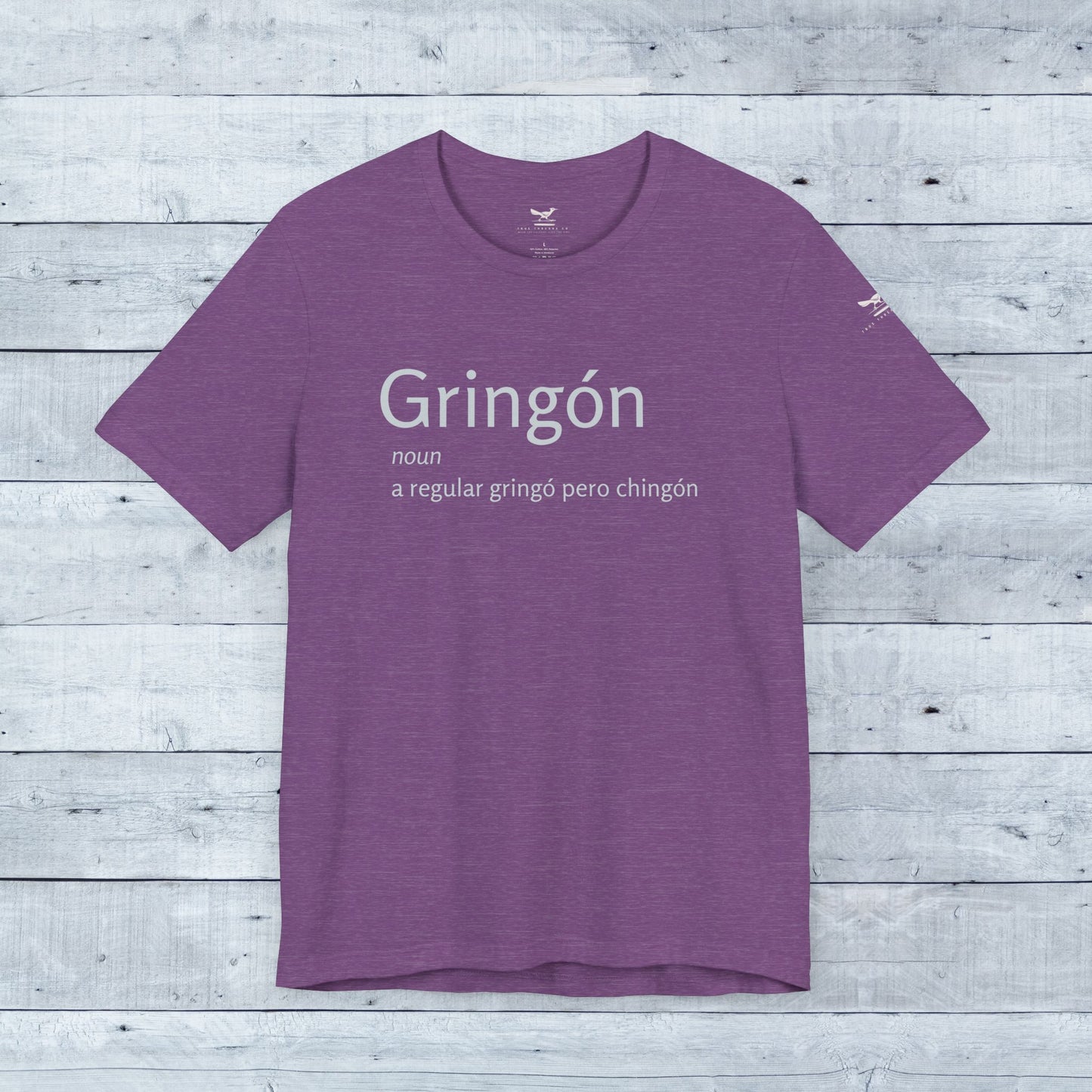 Gringón Tee: Unisex purple shirt with bold white text, crafted from soft tri-blend fabric, featuring a comfortable crew neck and sustainable manufacturing.