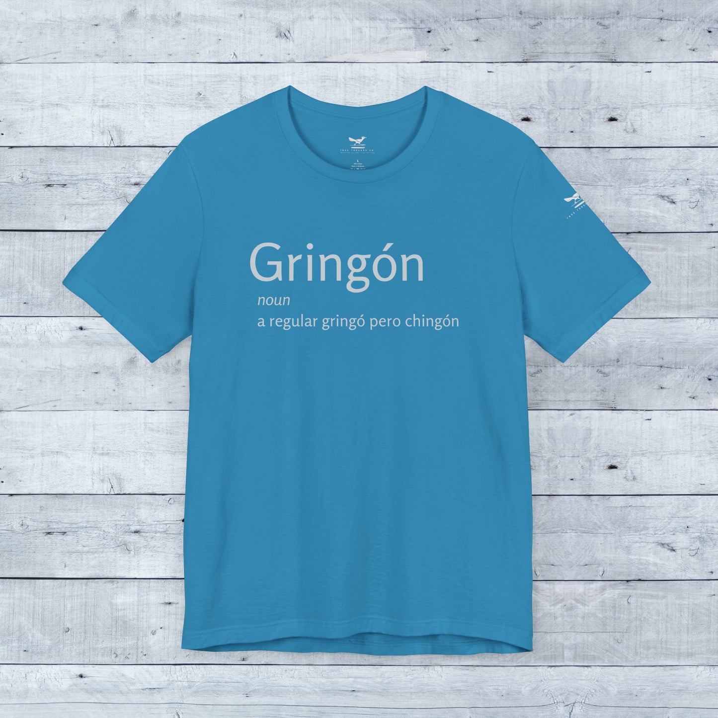 Gringón Tee: Blue shirt with bold white text, showcasing a fusion of cultures. Soft tri-blend fabric, unisex fit, perfect for confident, stylish wear.