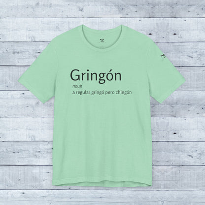 Gringón Tee close-up displays bold black text on soft green fabric, a stylish unisex crew neck for confident, cultural expression and comfort.