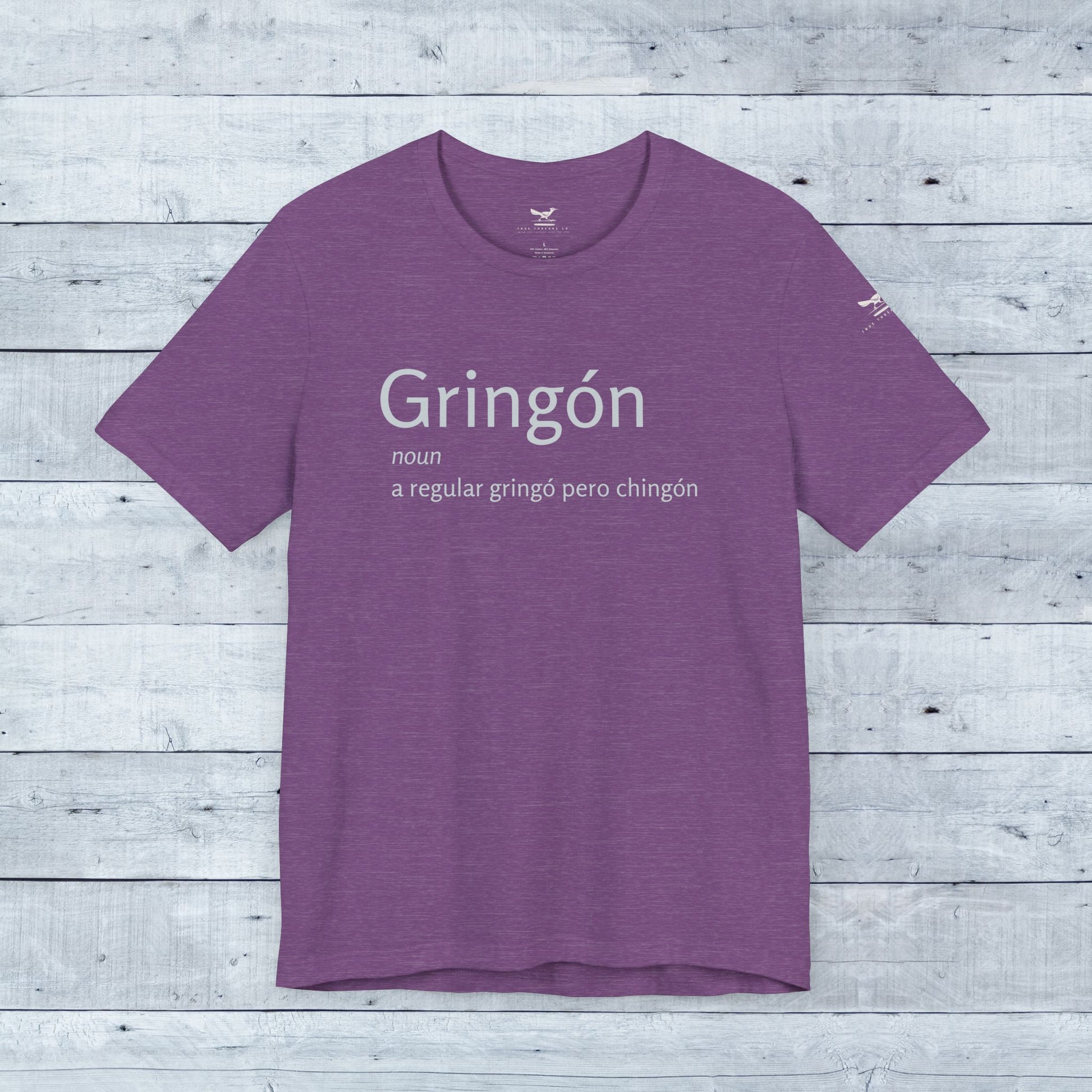 Gringón Tee: Unisex purple shirt with bold white text, crafted from soft tri-blend fabric, featuring a comfortable crew neck and sustainable manufacturing.